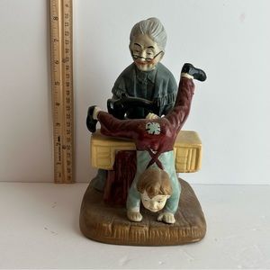 Vintage ceramic grandmother sewing pants on boy